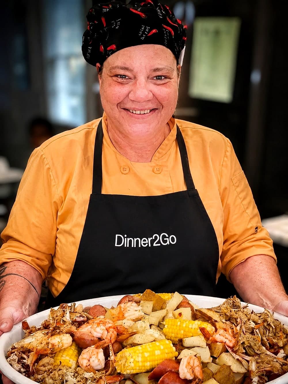 Chef Renee in her Dinner2Go apron holding a fresh Lowcountry boil platter